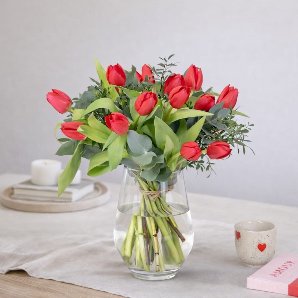 Elegancia minimalista con tulipanes rojos frescos y eucalipto. Un clásico sofisticado para expresar amor puro sin excesos.
